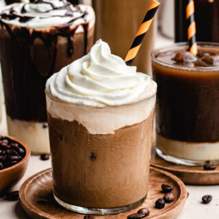 Glass with cold coffee drink, topped with whipped cream.