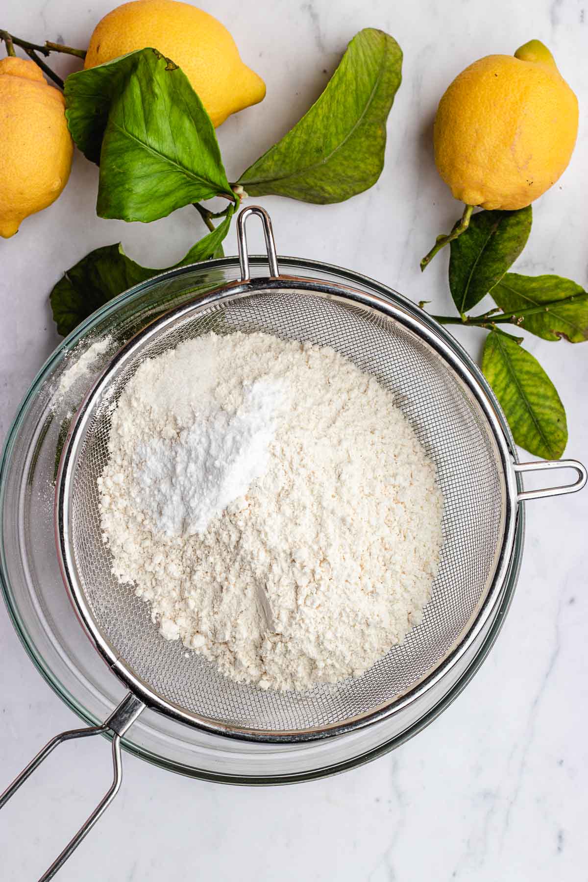 Lemon Olive Oil Cake sifting flour and dry ingredient.