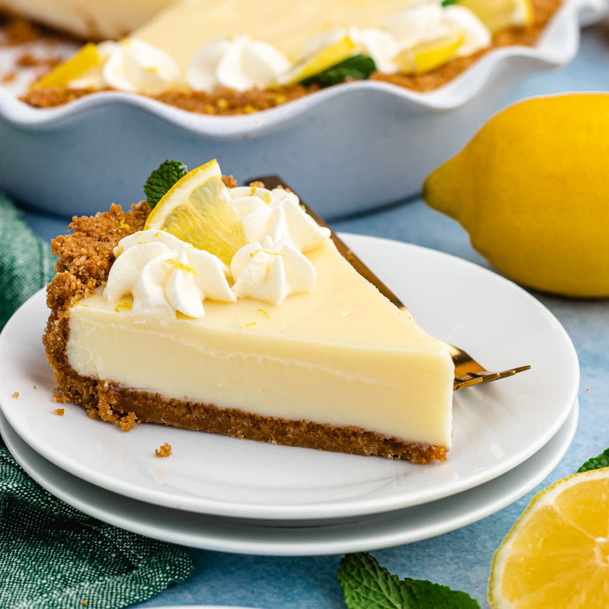 Lemon Pie slice of pie on plate with pie plate with fork