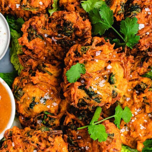 Pakora on serving plate with dipping sauces.