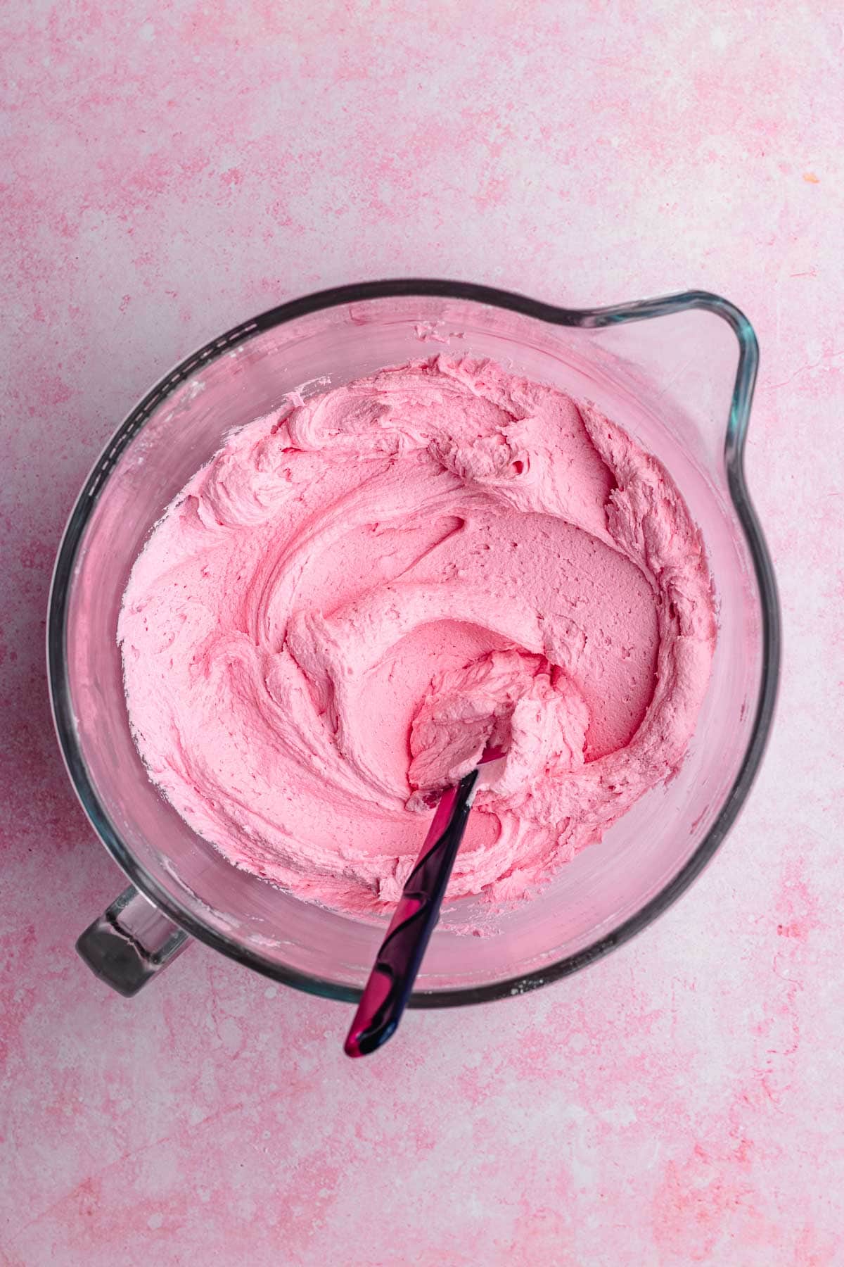 Pink Velvet Cake frosting mixed in bowl with spatula