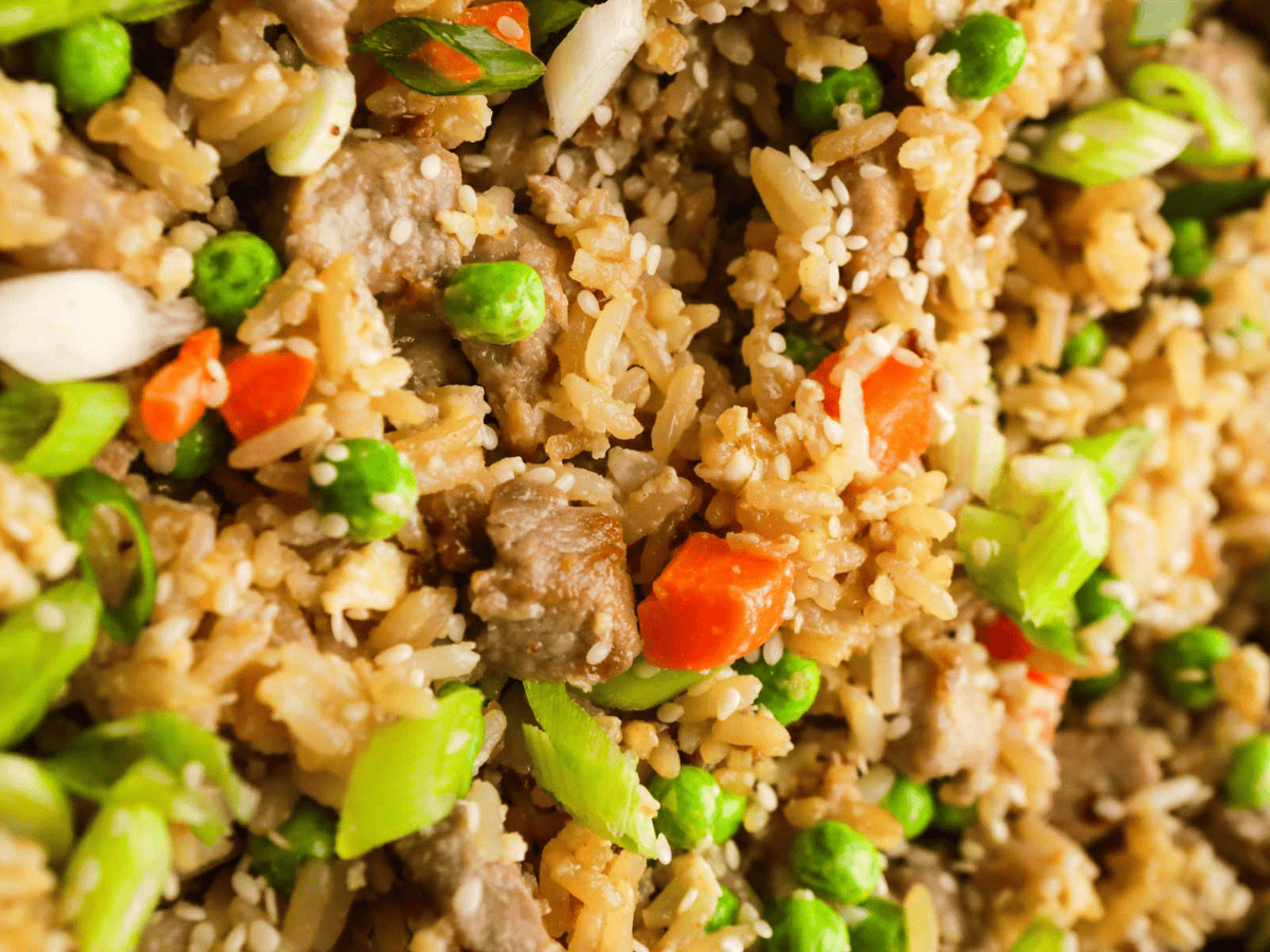 Zoomed in picture of fried rice with peas and carrots