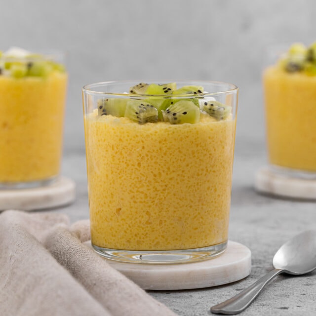 Tapioca in a clear glass dessert cup, topped with cubed kiwi.