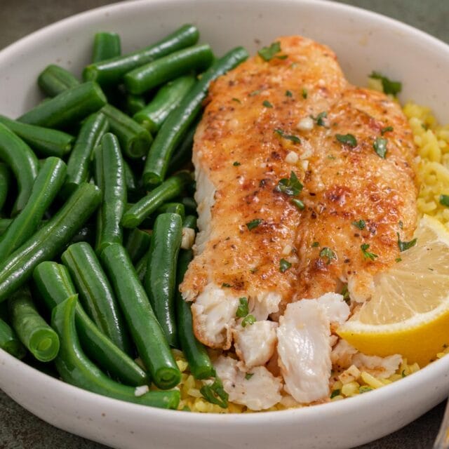 Fish, green beans, and rice in dinner bowl.