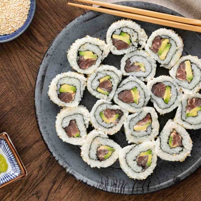 Spicy Tuna Rolls with chopsticks, soy sauce, wasabi and spicy mayo.
