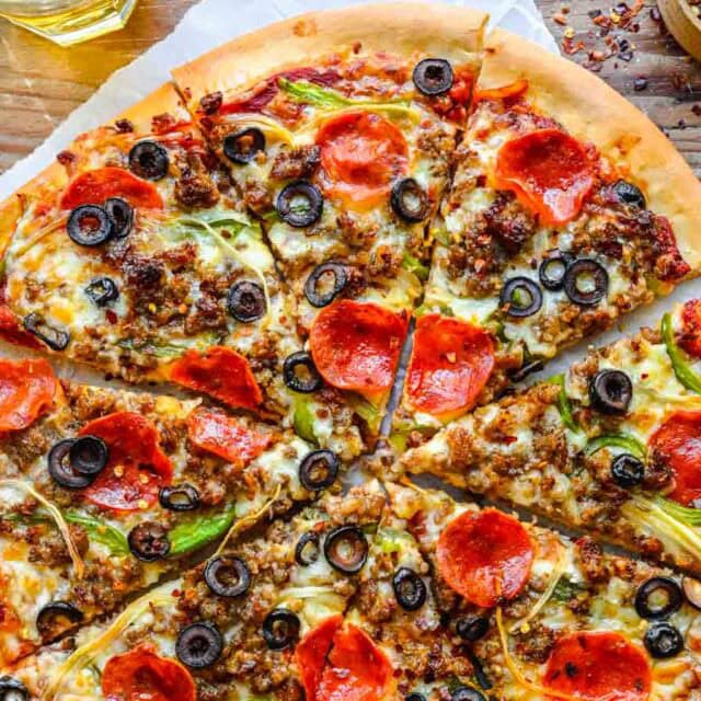 cheese, pepperoni, sausage, and bell peppers on whole sliced pizza