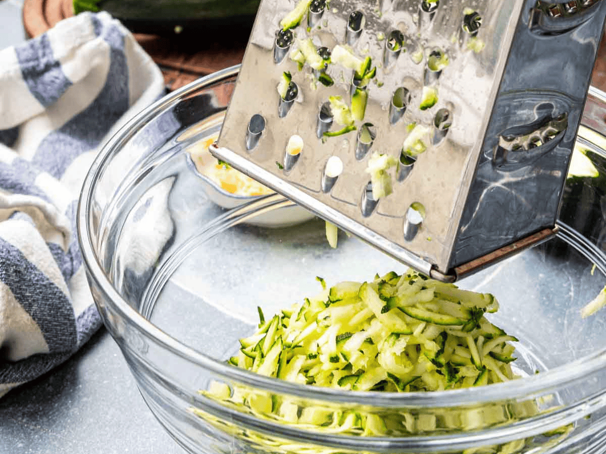 Box grater grating zucchini.