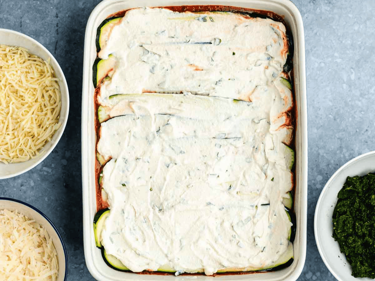 Layer of vegetables and ricotta in baking dish.