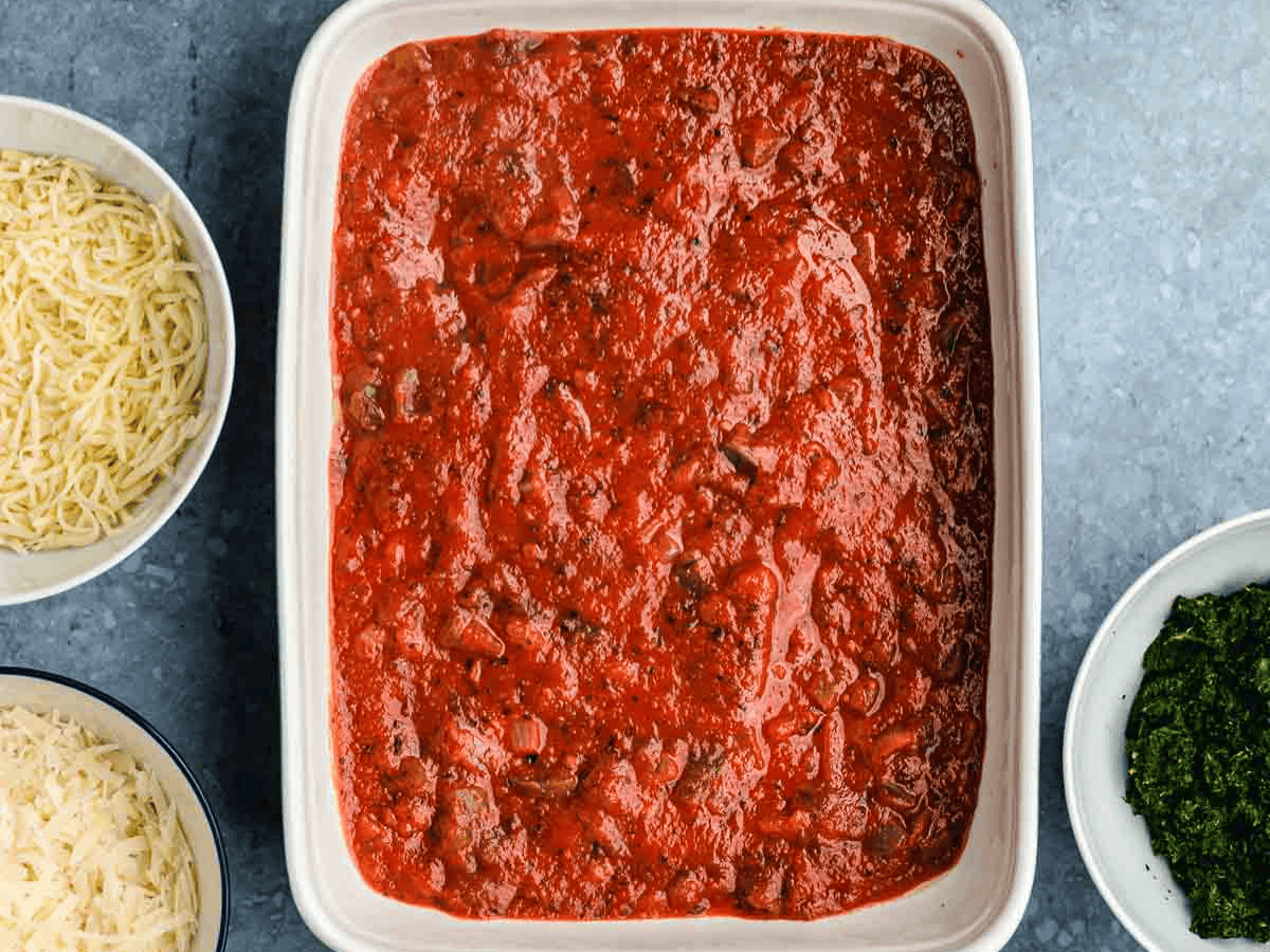 Layer of tomato sauce in baking dish.