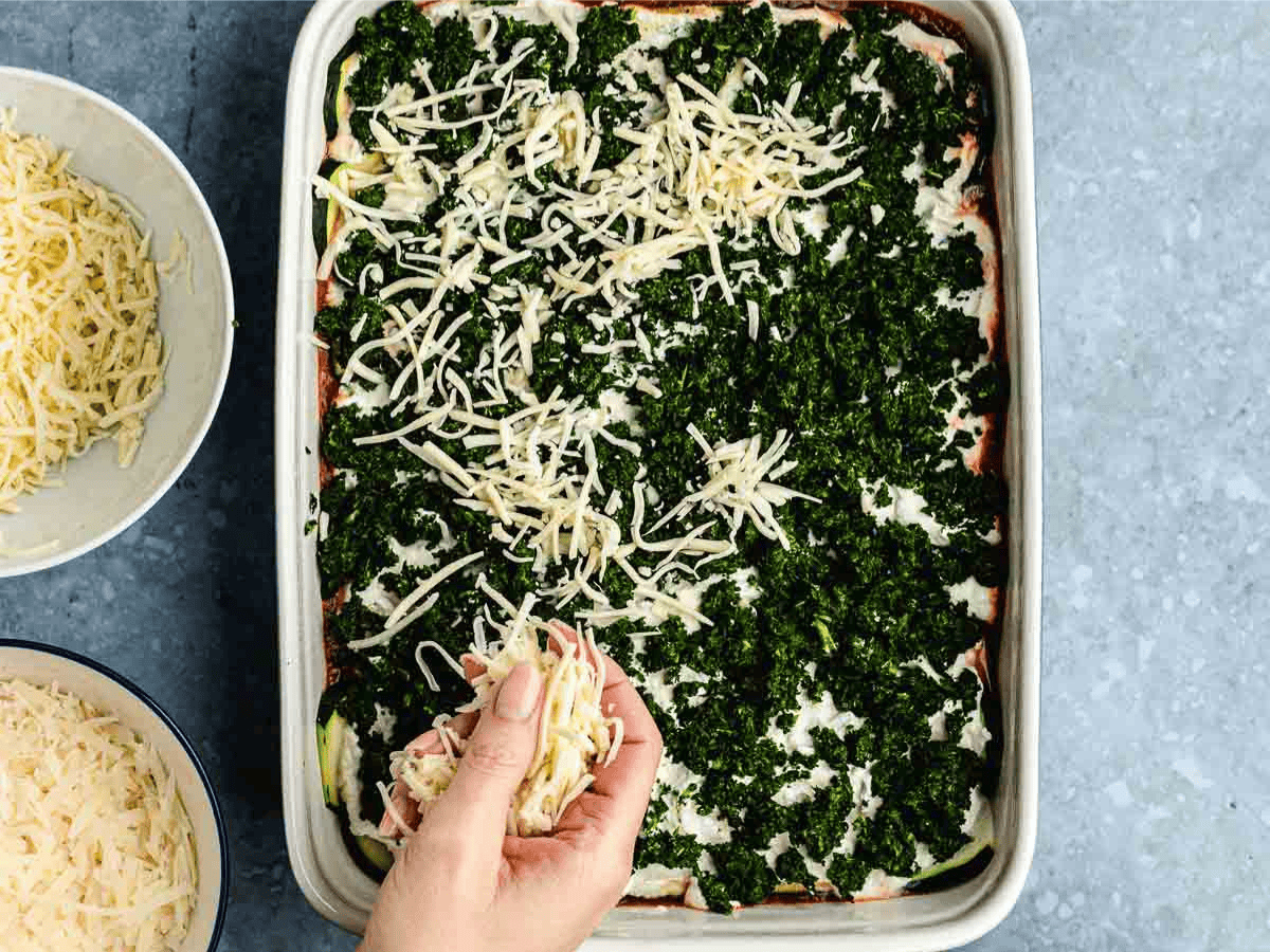 Layer of spinach and cheese in baking dish.