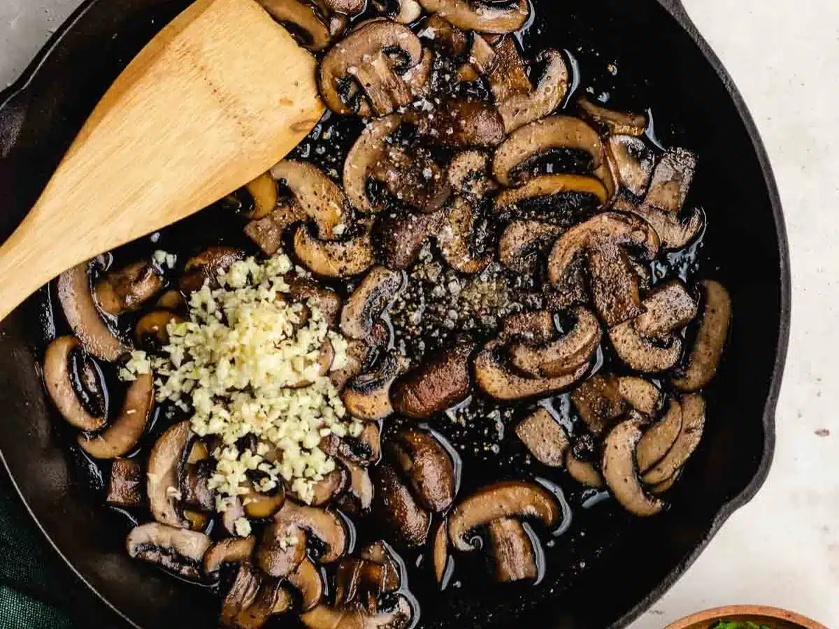 Mushrooms and garlic sautéing in pan.