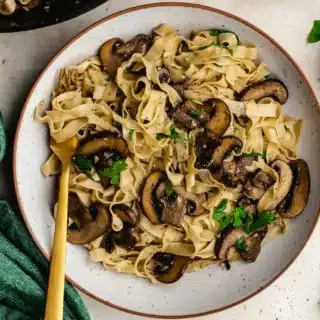 Dinner plate with pasta and sautéed mushrooms.
