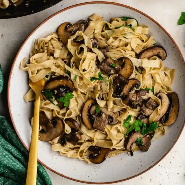 Dinner plate with pasta and sautéed mushrooms.