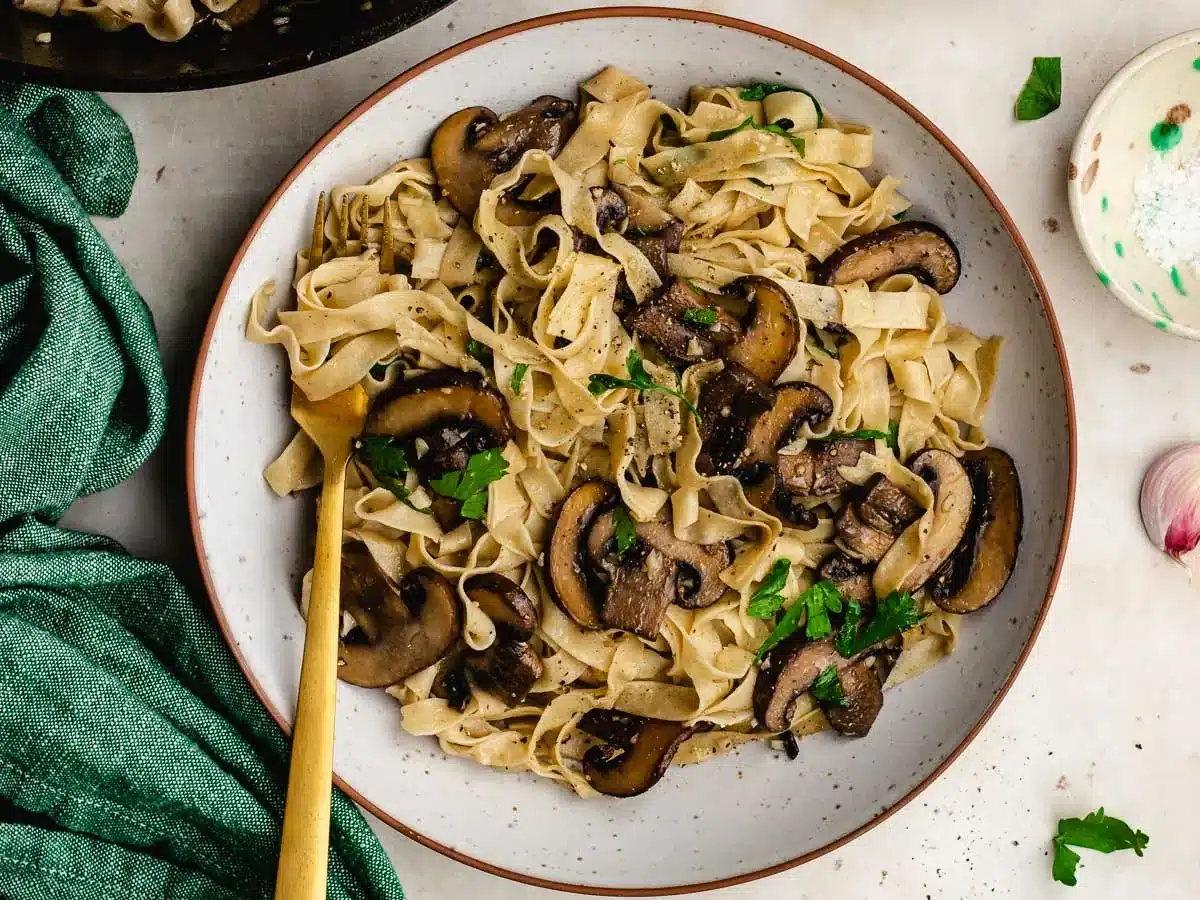 Dinner plate with pasta and sautéed mushrooms.