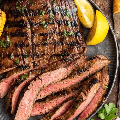 Sliced, grilled flank steak on serving plate.