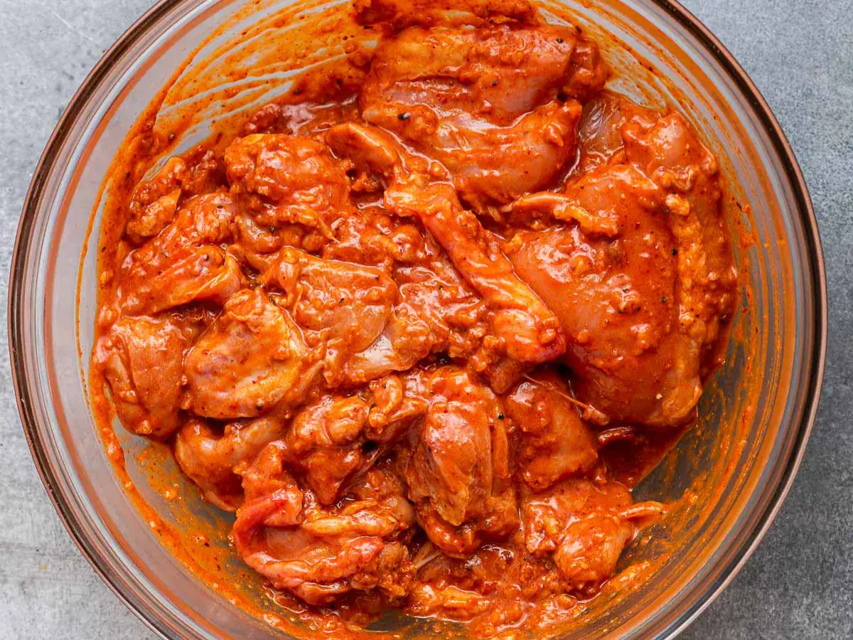 Chicken marinating in bowl.