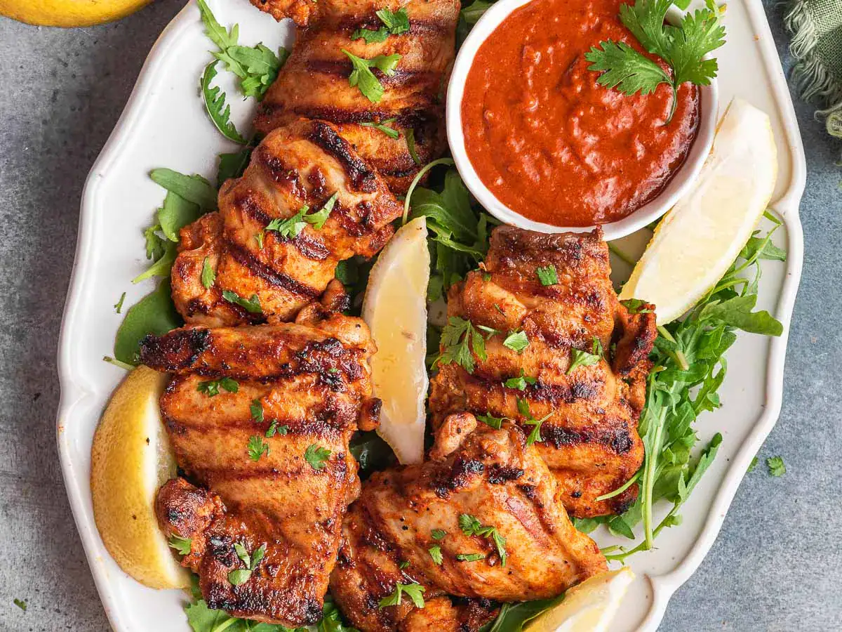 Grilled chicken thighs on serving plate.