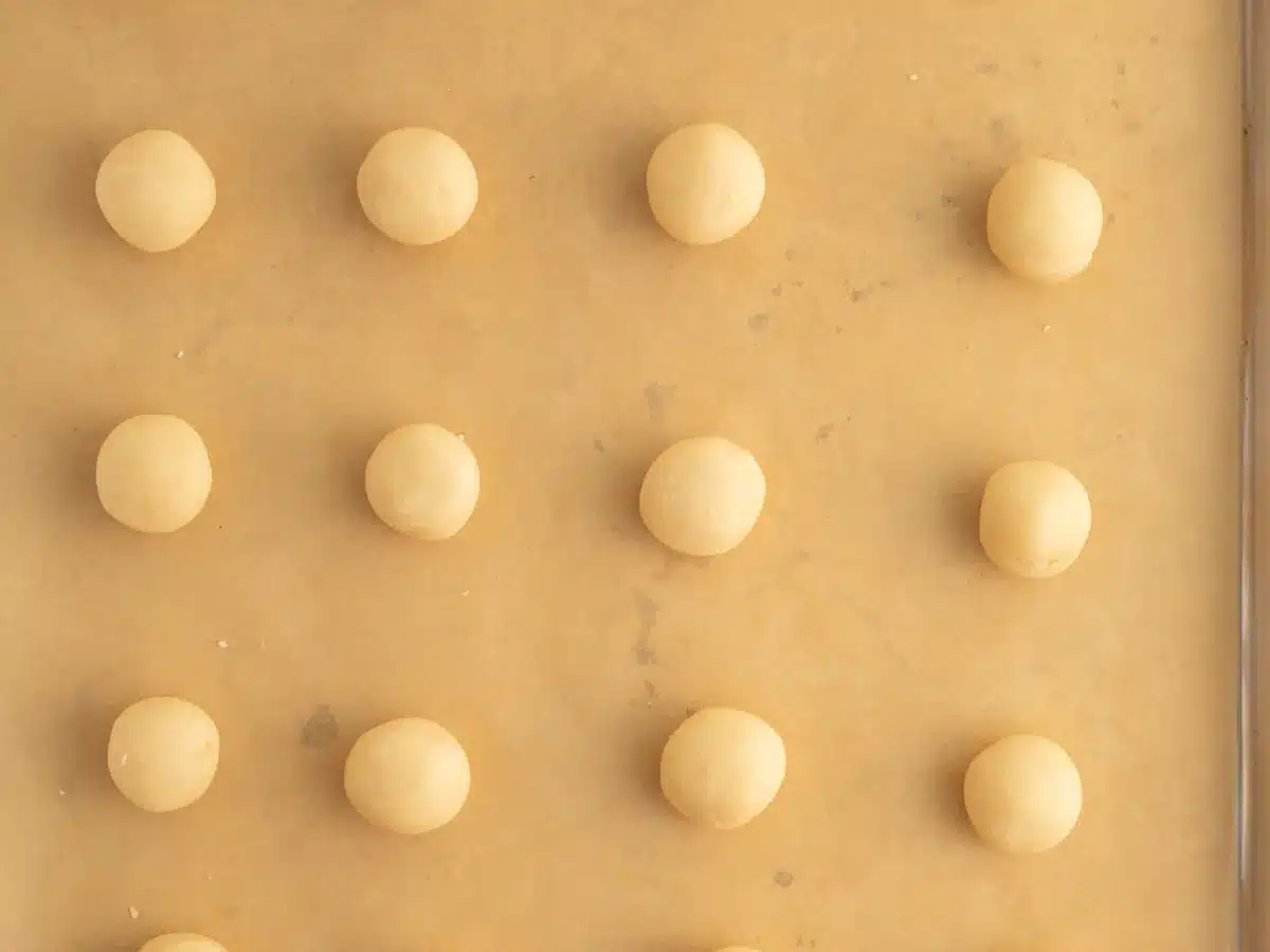 Raw dough balls on parchment paper.