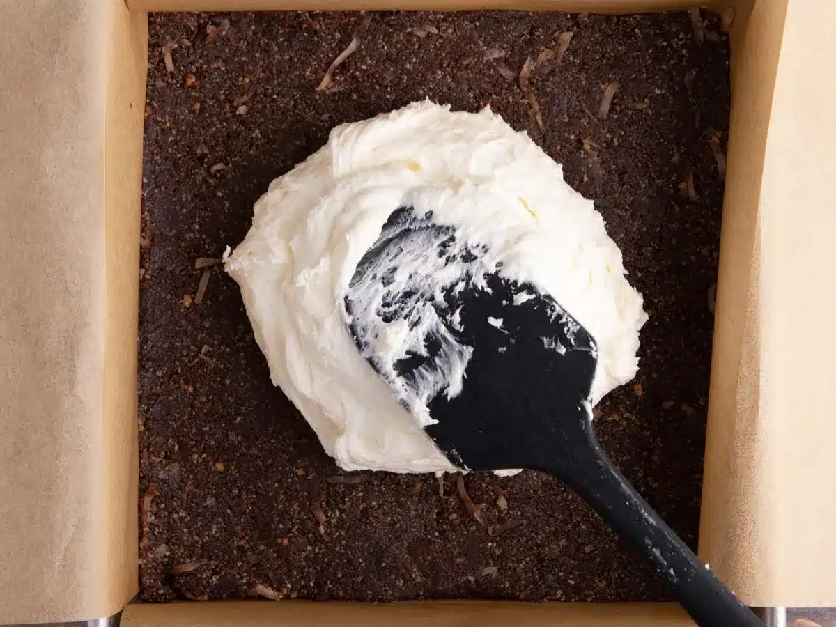 Creamy custard layer spread on top of chocolate and biscuit layer.