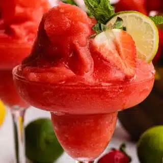 Close up of a frozen cocktail with strawberry garnish.