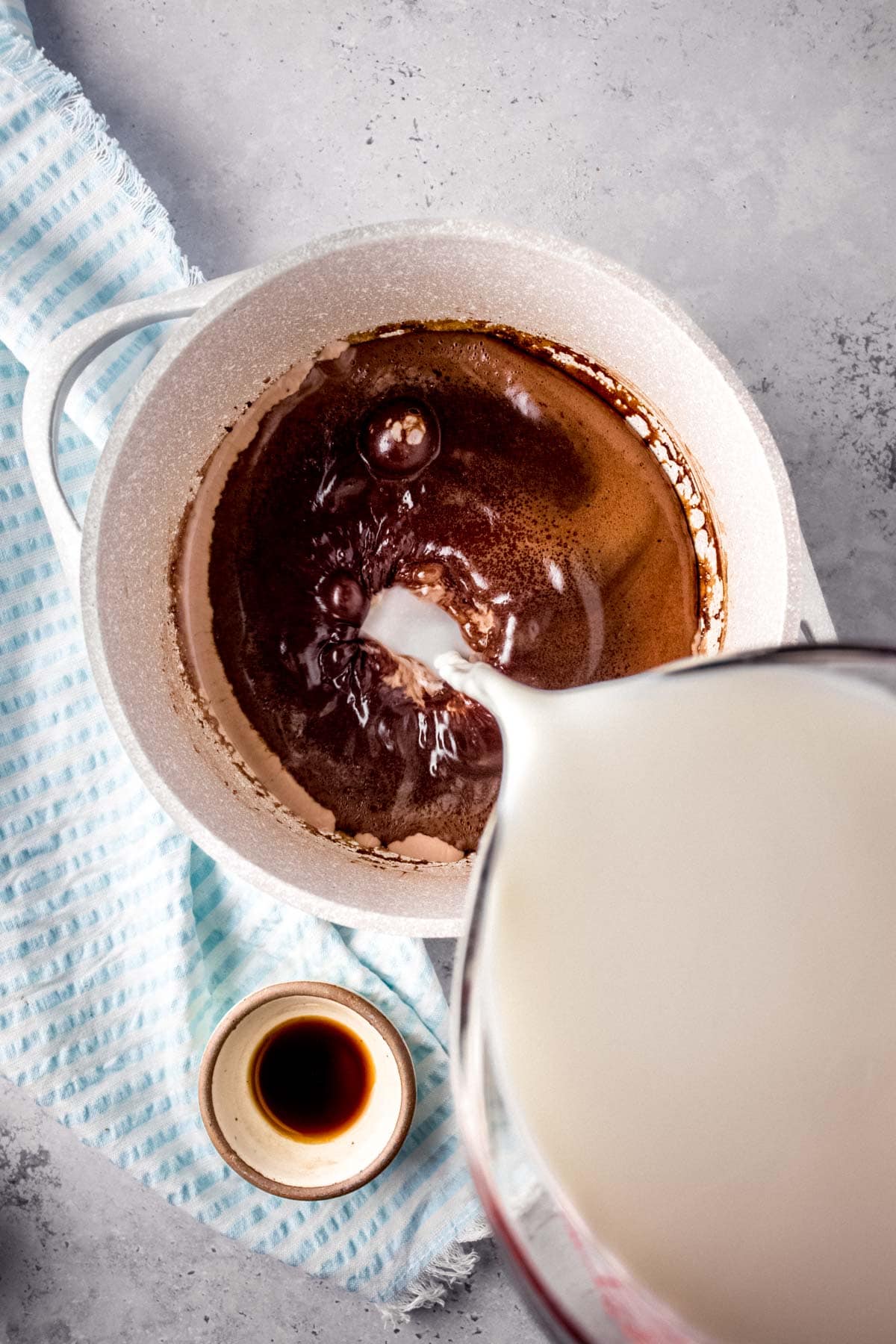 Chocolate Milk pouring milk into chocolate mixture in pan