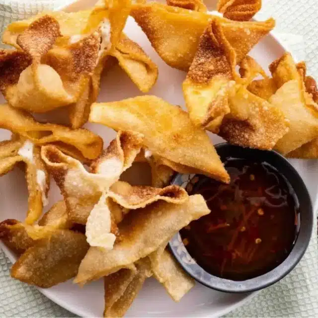 Top view of rangoons served with sauce