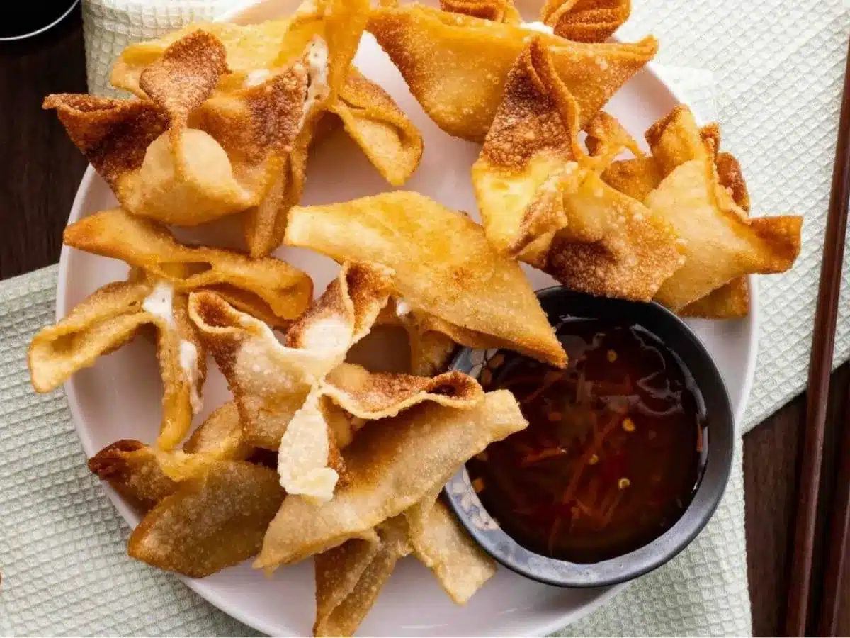 Top view of rangoons served with sauce