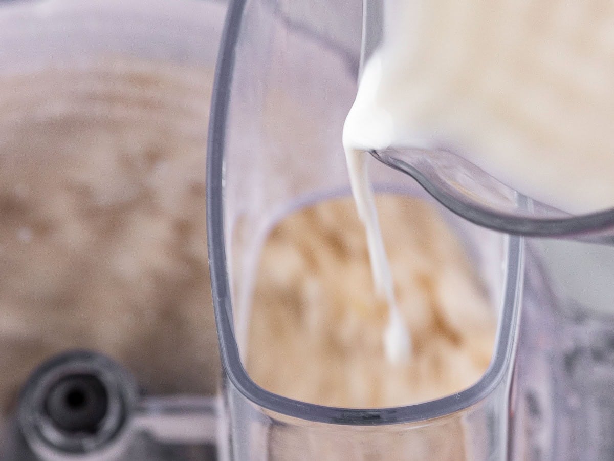 Pouring milk into food processor chute