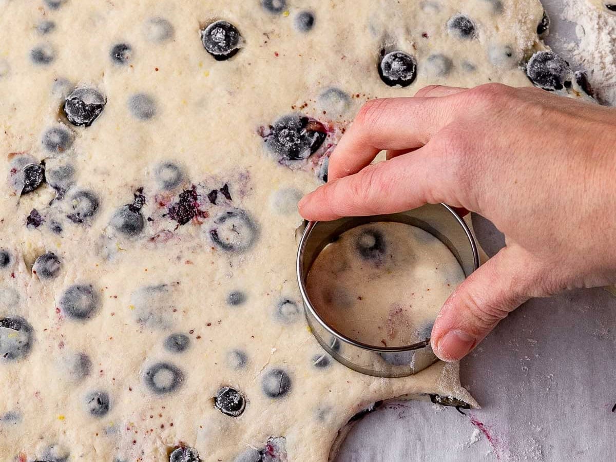 Using a biscuit cutter to cut out biscuits