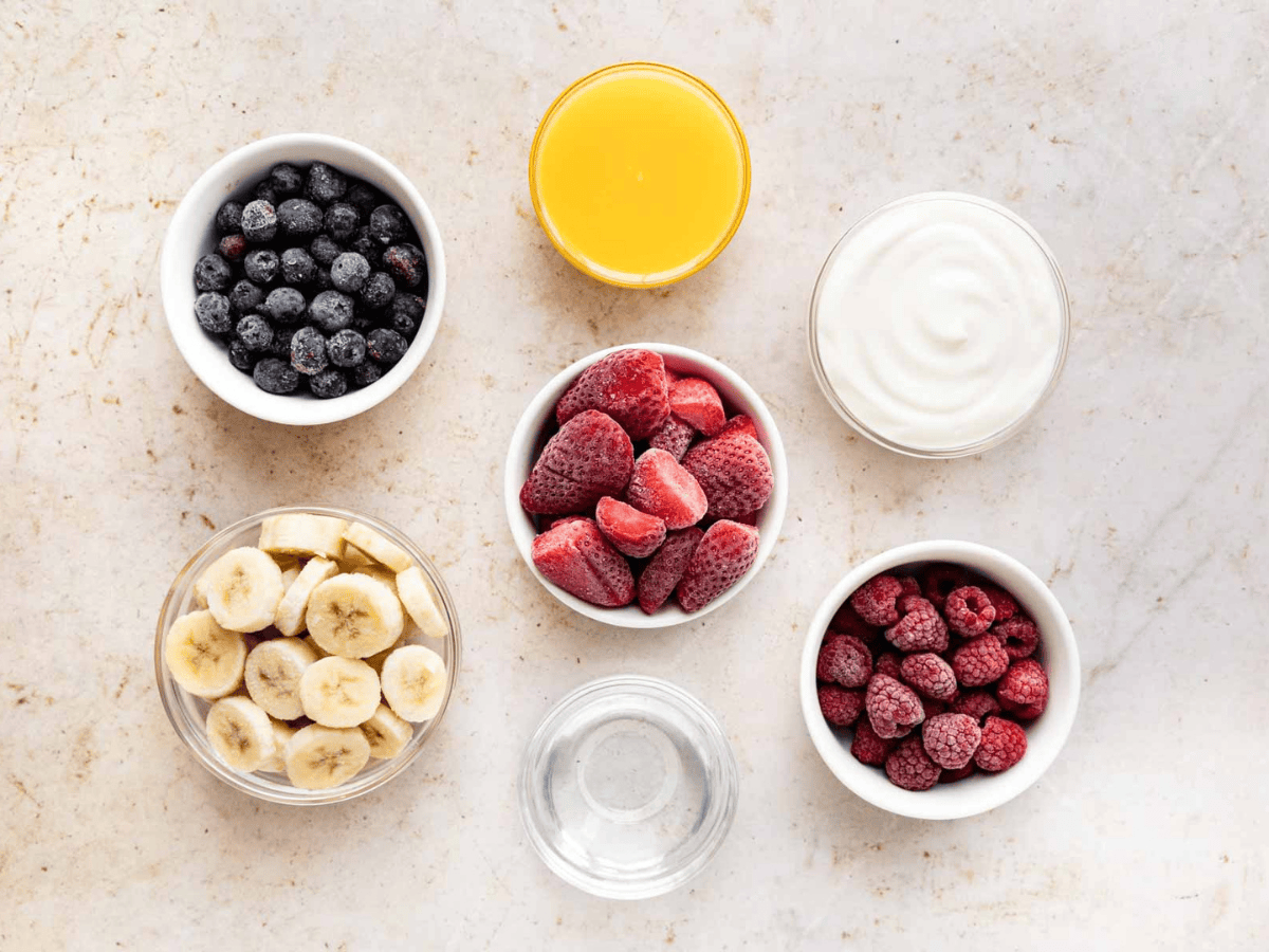Ingredients for blended fruit drink in individuals bowls.