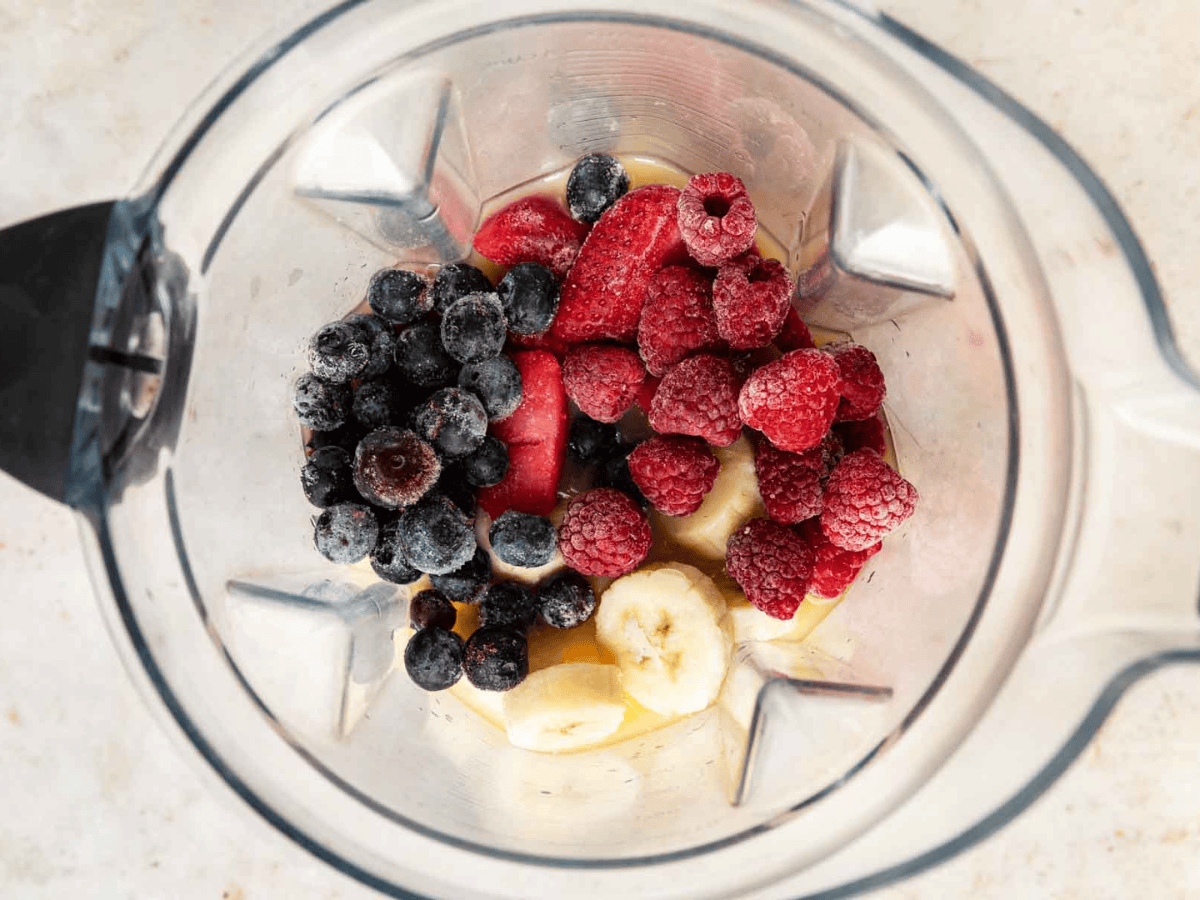Blueberries, strawberries, raspberries and bananas in a blender.