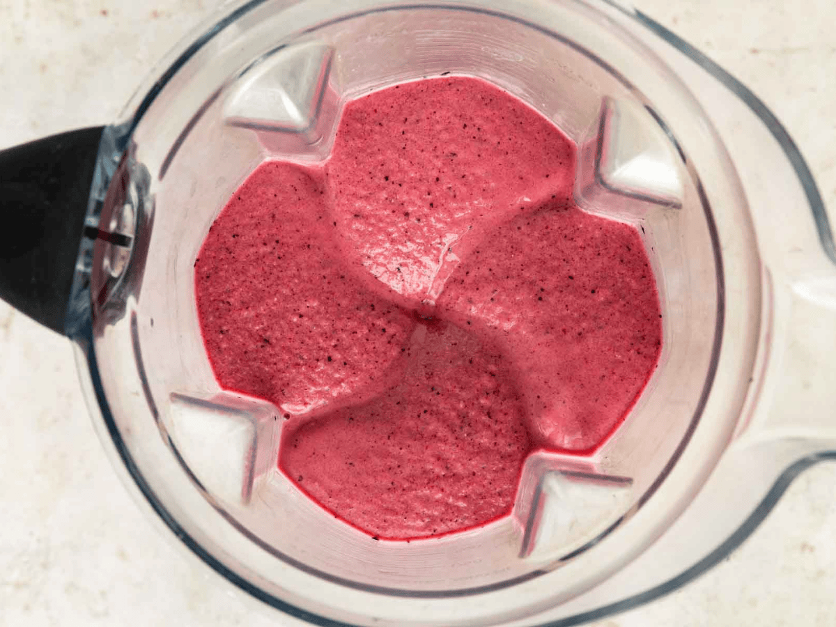 Blended fruit drink in the glass blender container.