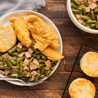 Cooked ingredients on a table with chicken and a biscuit served on a plate