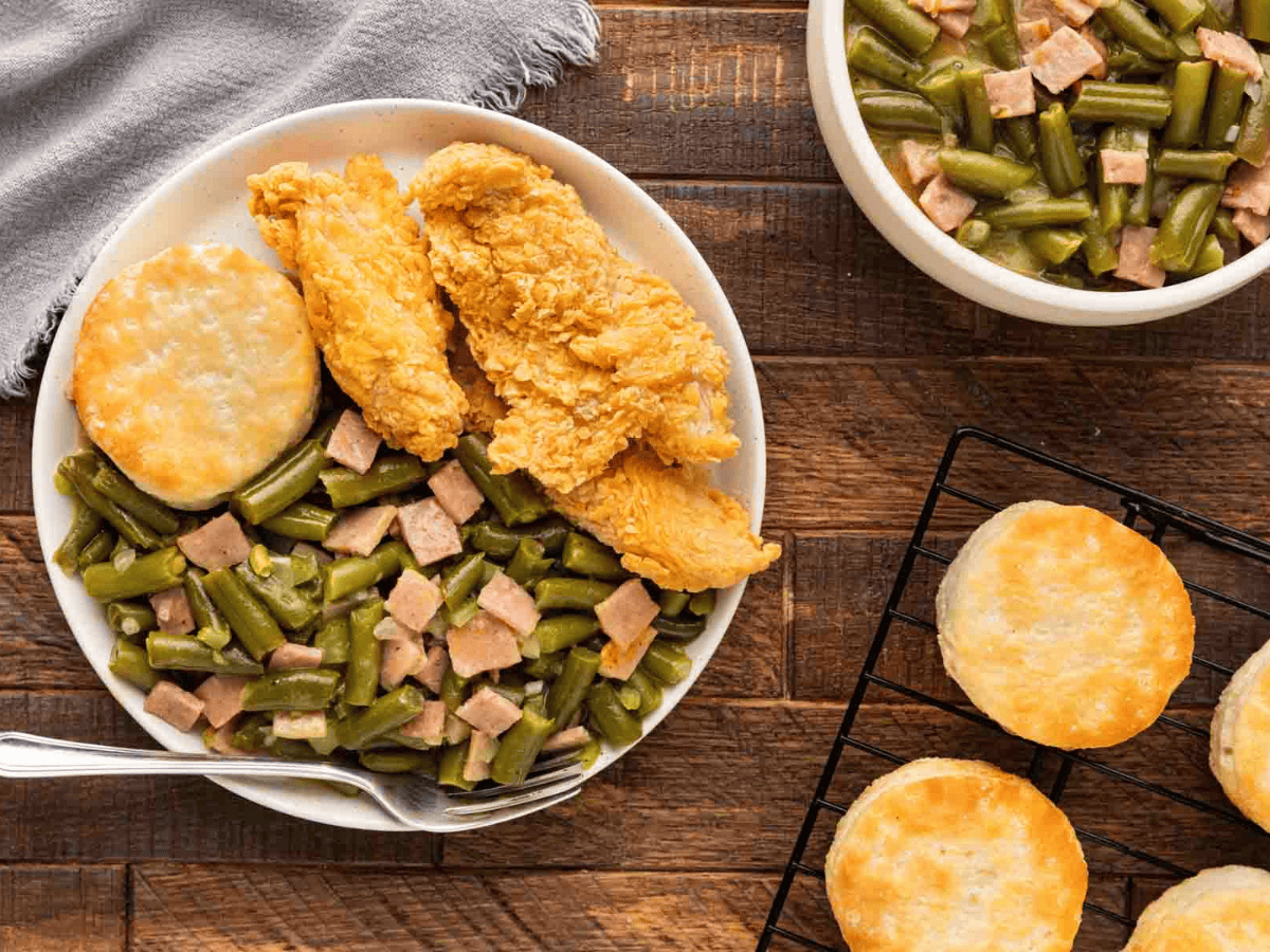Cooked ingredients on a table with chicken and a biscuit served on a plate 