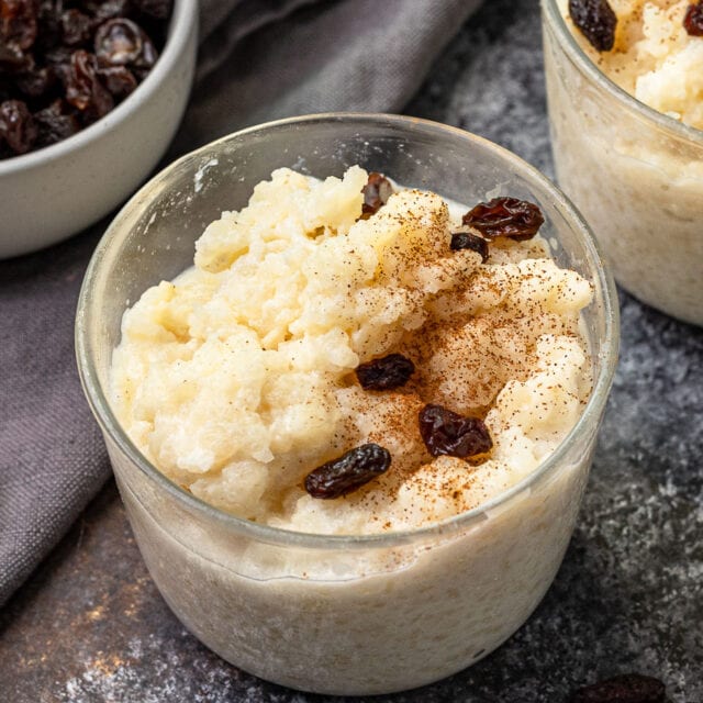 pudding topped with raisins in a glass