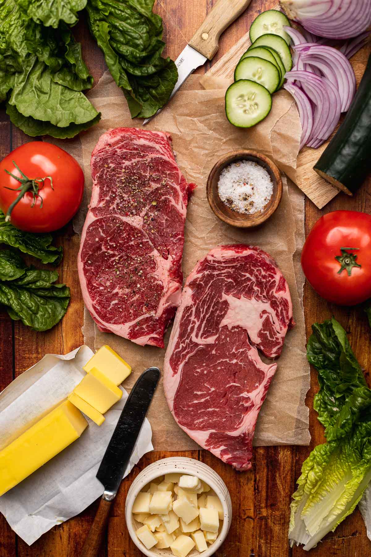Steak Salad ingredients and raw steaks on cutting board