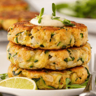 stack of veggie patties on a plate with lime on the side