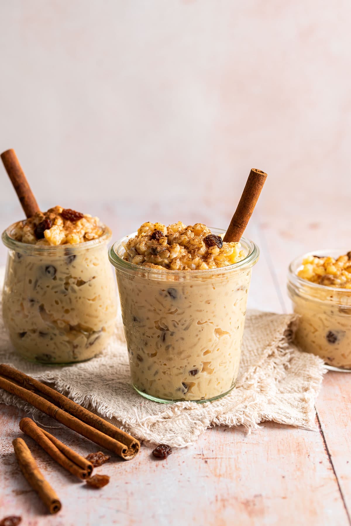 Arroz con Leche finished pudding in glass cup and jars with cinnamon stick