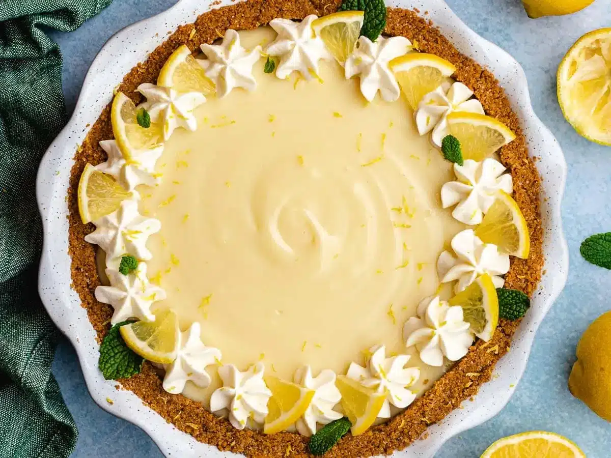 pie in pan decorated with whip cream and lemons