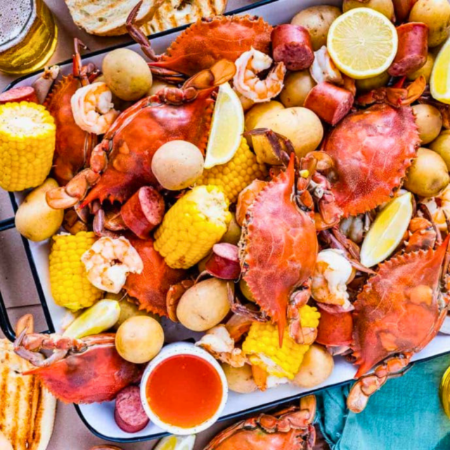 Seafood boil on platter with bread and beer