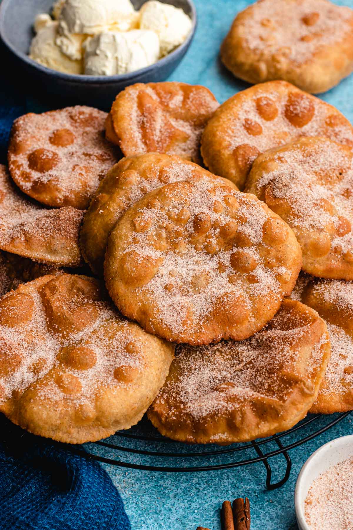 Mexican Bunuelos fried bunuelos covered in sugar and piled on a plate
