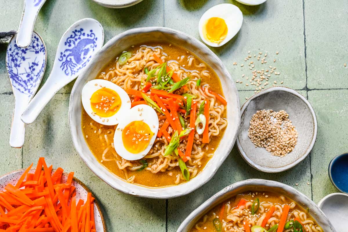 Miso Ramen finished soup in bowl with toppings, garnishes spread around decoratively