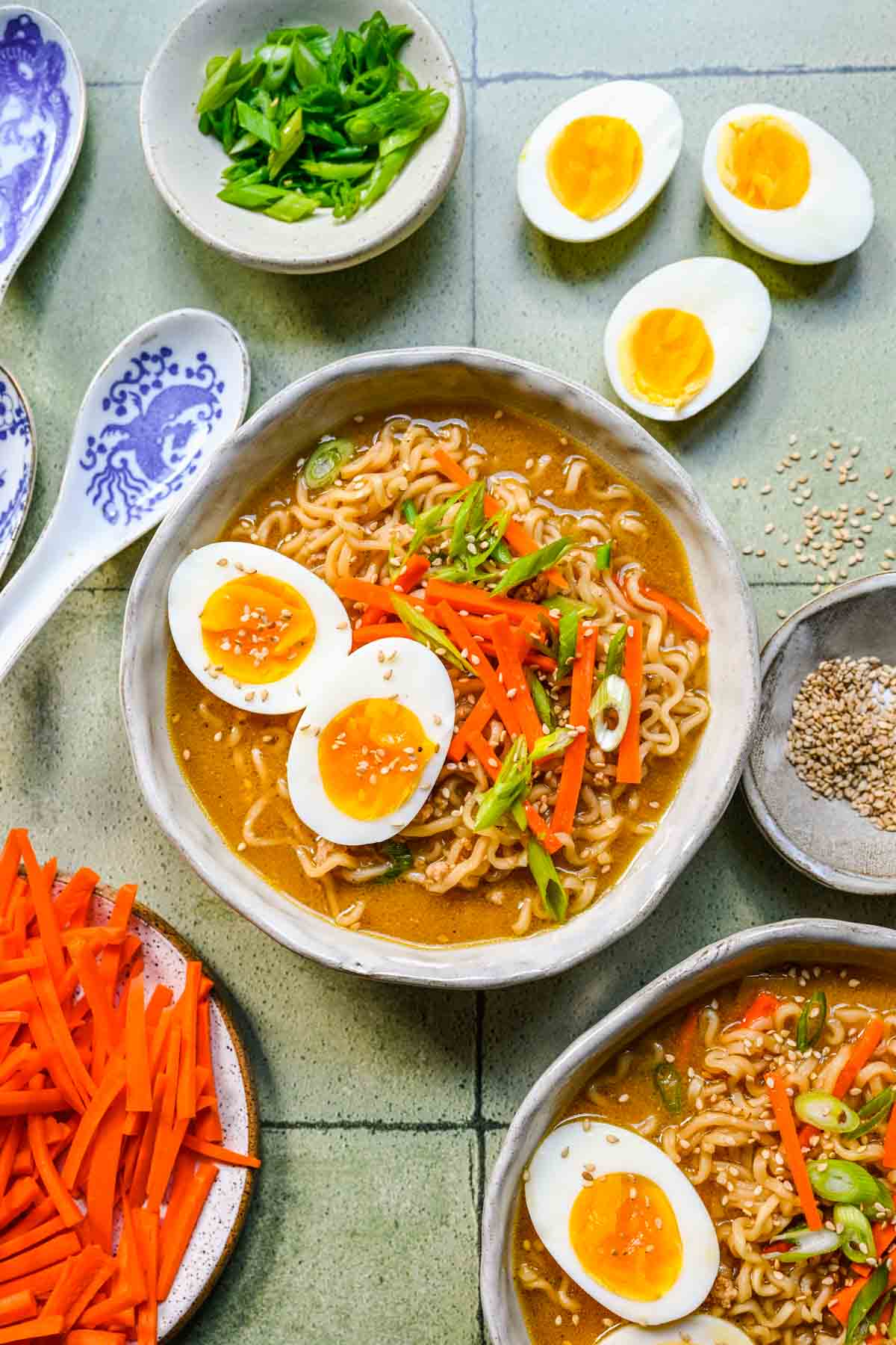 Miso Ramen finished soup in bowls with toppings, garnishes spread around decoratively