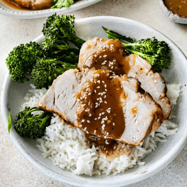 Plate of roast on a bed of rice and broccoli
