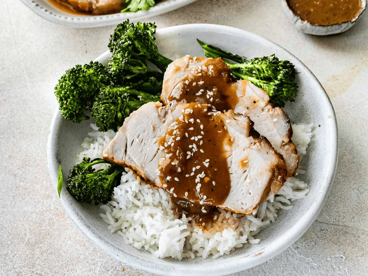 Plate of roast on a bed of rice and broccoli