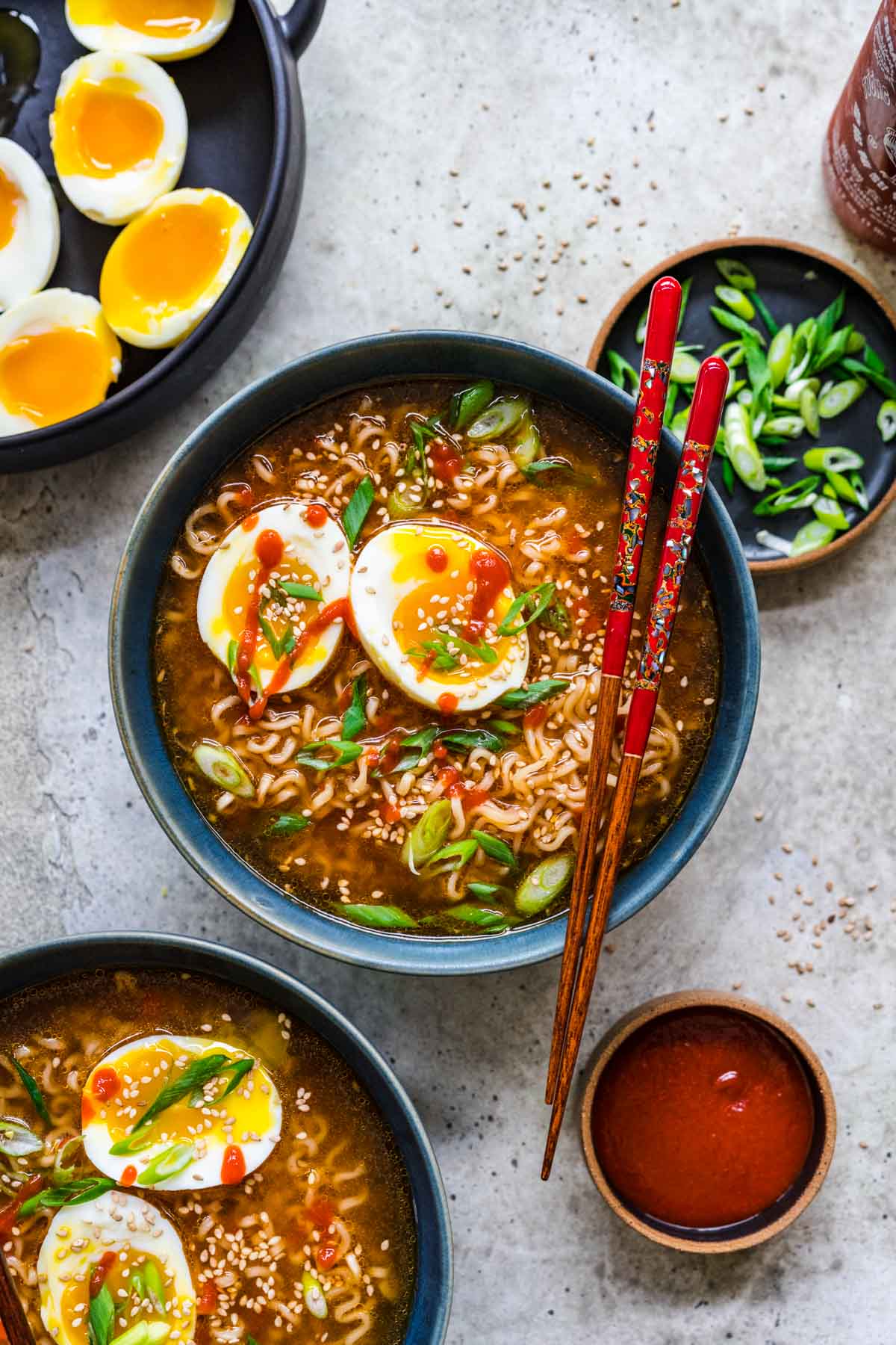 Spicy Ramen finished ramen with toppings in bowls and chopsticks resting on center bowl