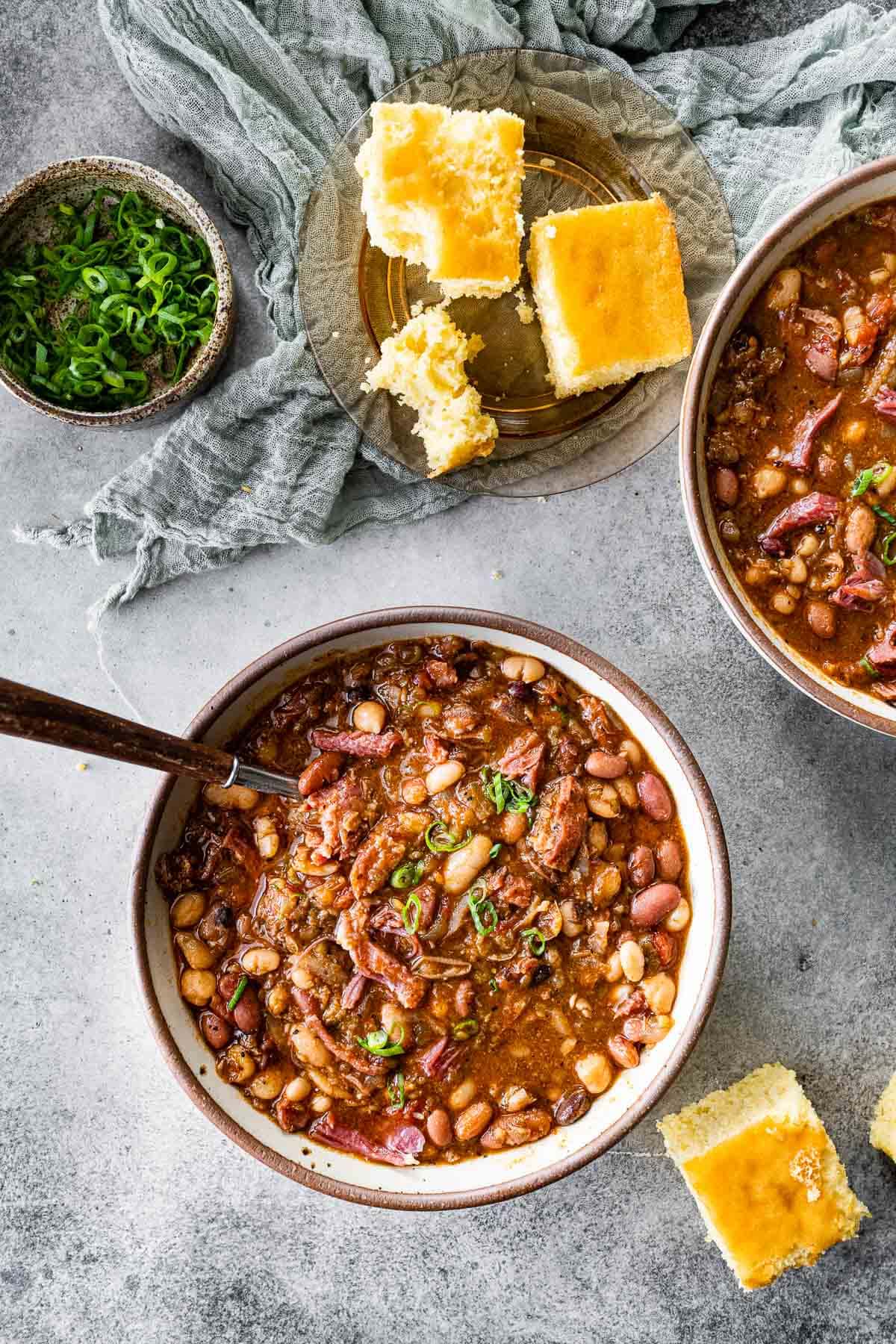 15 Bean Soup cooked soup in bowl with spoon and cornbread pieces on side