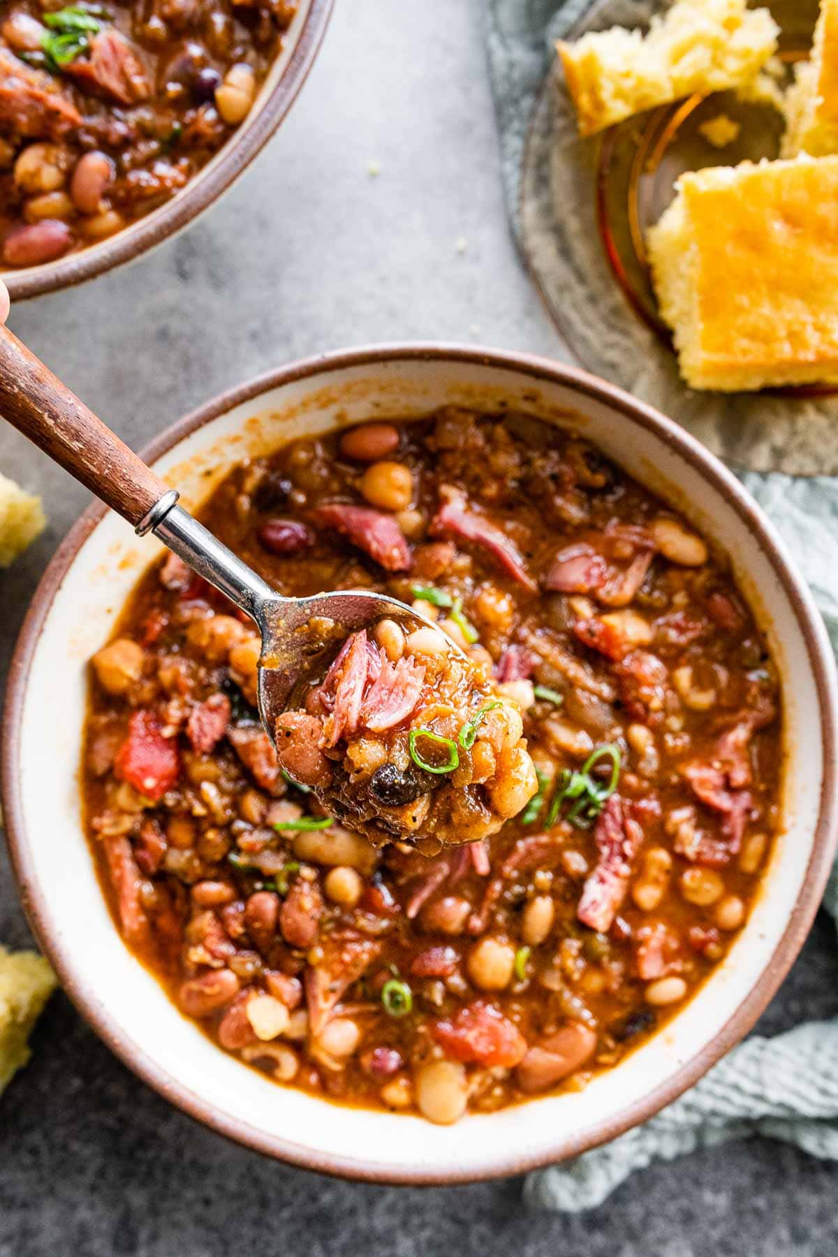 15 Bean Soup cooked soup in bowl with spoon and cornbread pieces on side