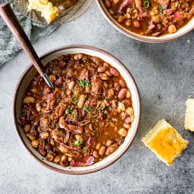 15 Bean Soup cooked soup in bowl with spoon and cornbread pieces on side