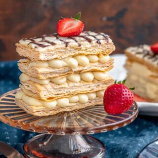 Layered French pastry on serving plate with strawberry garnish.